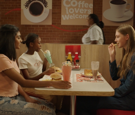 Group of friends enjoying a milkshake at a table